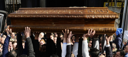 Al funerale di un commerciante morto per una rapina, suo figlio abbraccia quello del ladro