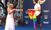 Con la bandiera arcobaleno sul palco di Giorgia Meloni. Lei scherza: "Me la vuoi lasciare, grazie?"
