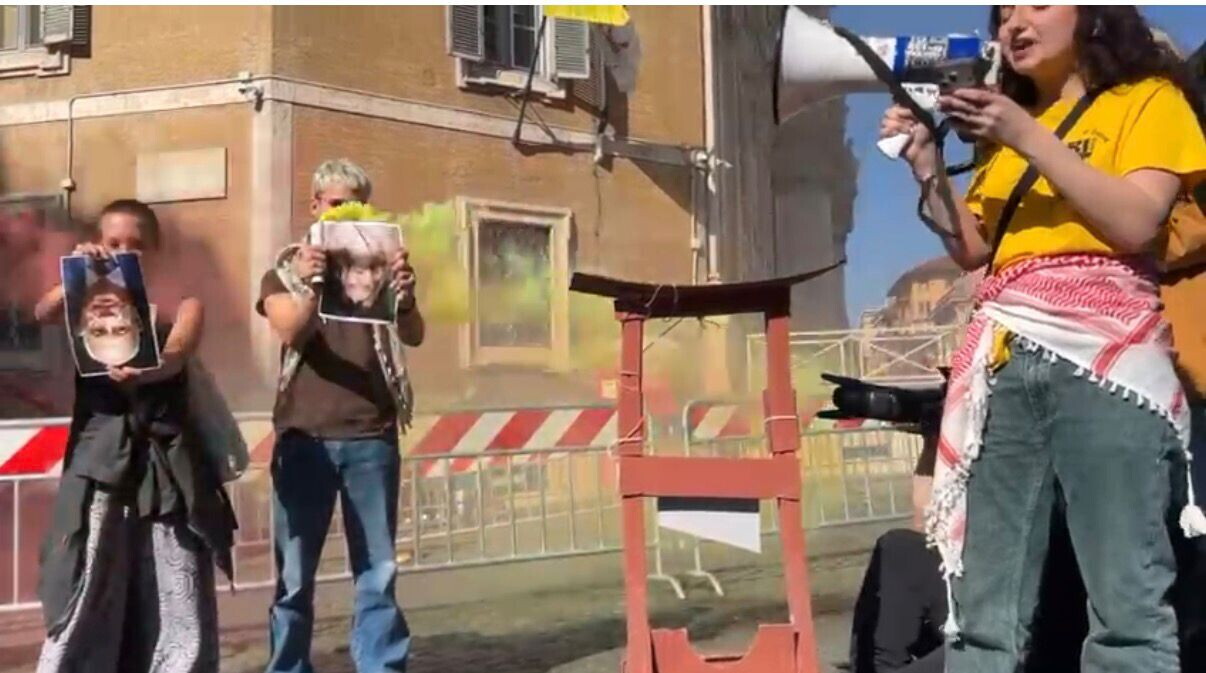 Foto di Meloni a testa in giù vicino a una ghigliottina. Protesta FdI