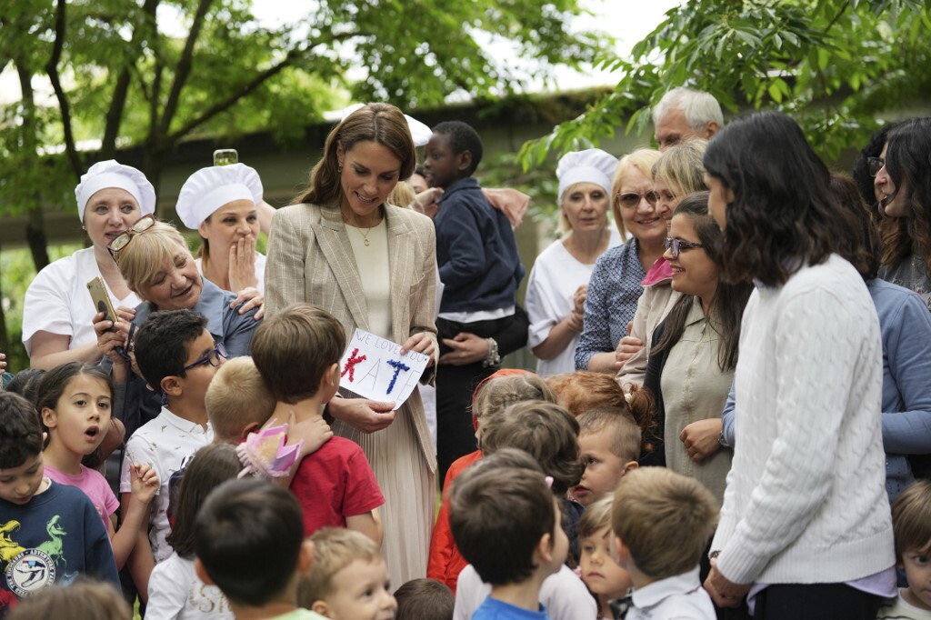 La principessa in mezzo al verde: blazer gessato e gonna plissé per l'incontro con i bambini
