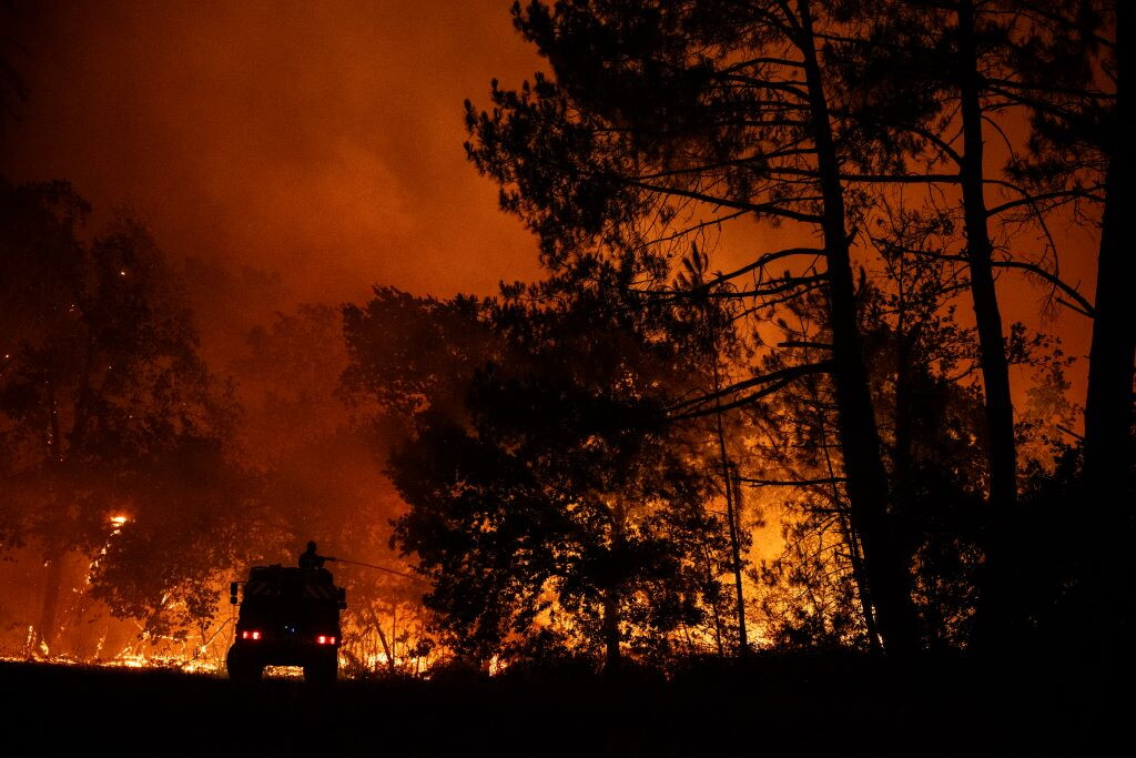 Fiamme divampano in una pineta vicino a villaggi, vigili del fuoco in azione con elicotteri, residenti in fuga dalle loro case
