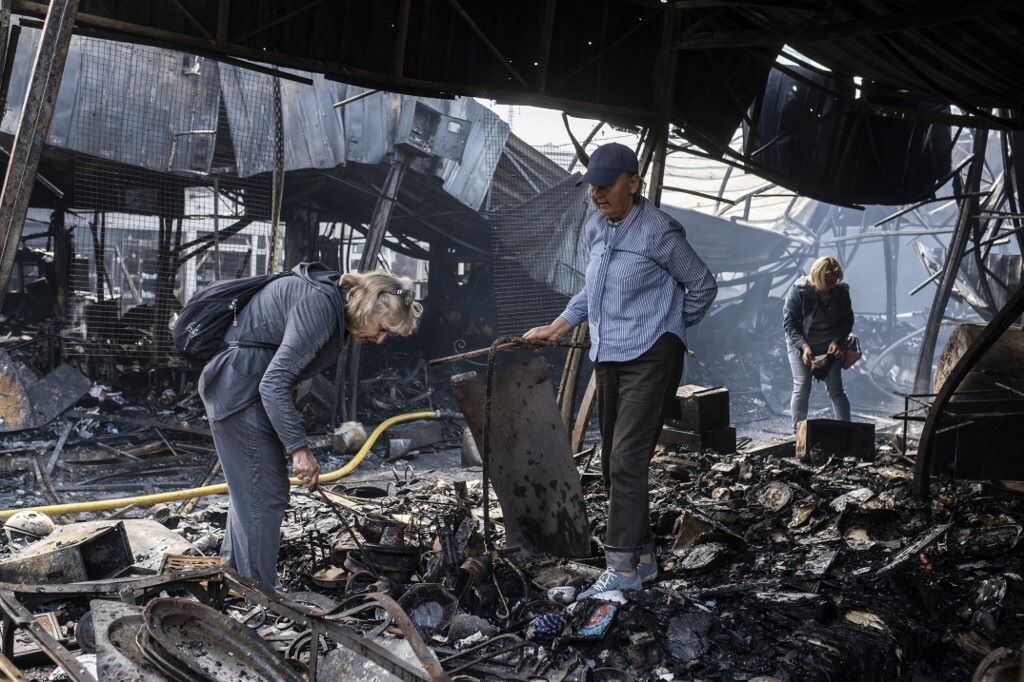 Vigili del fuoco intervengono per spegnere incendi in strada dopo bombardamenti notturni in città ucraina