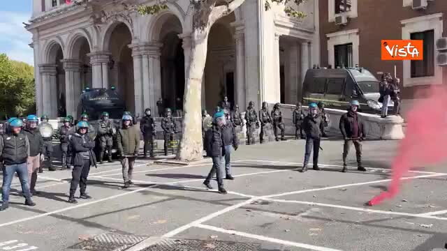 Un ragazzo si arrampica sul lampione della luce sotto al Mit e sventola la bandiera dell'Italia